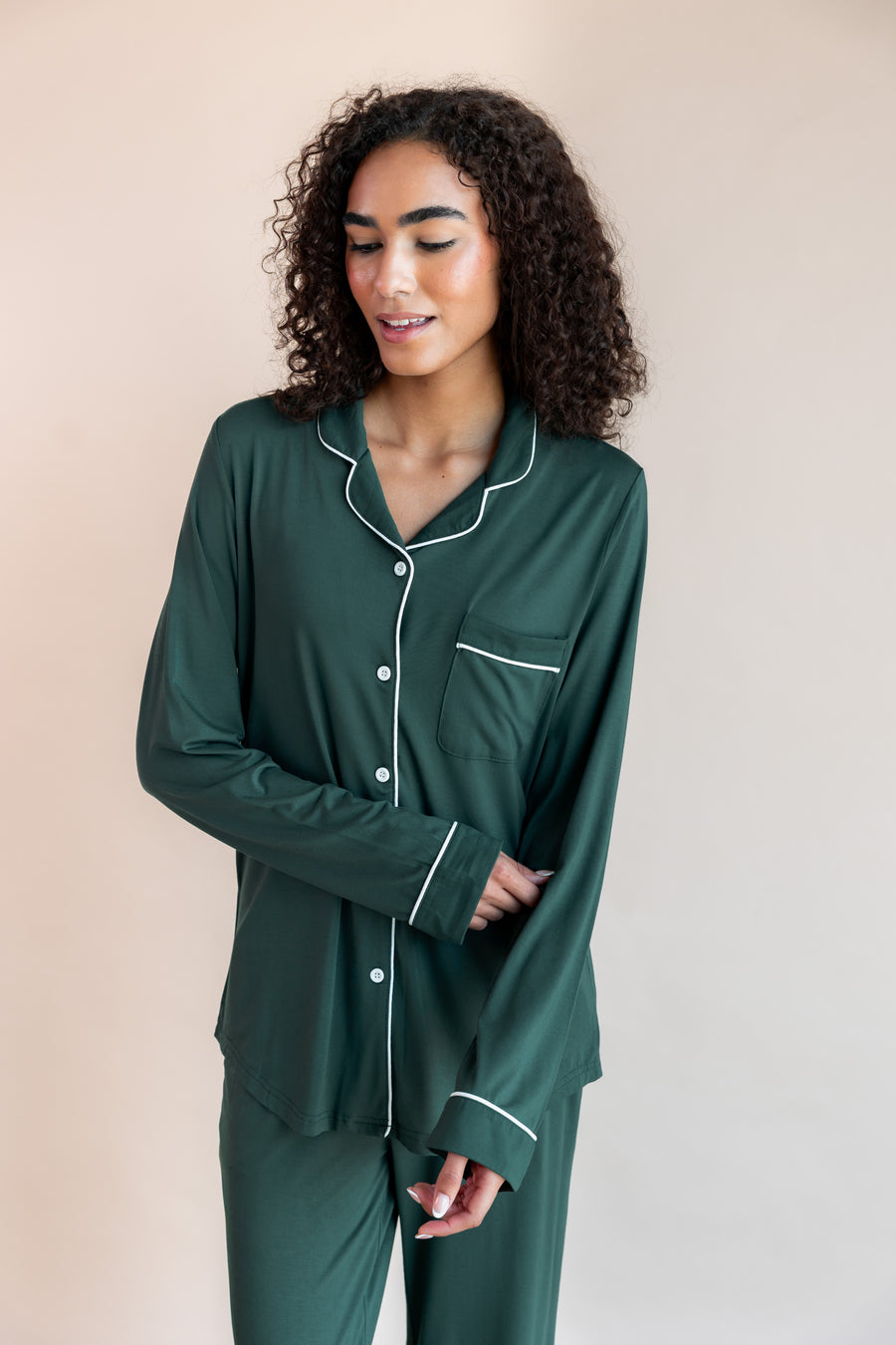 Woman pulling up her sleeve looking down wearing long sleeve pajama set in cypress