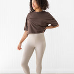Model looking to the side while wearing the Flex Leggings in Bisque with hand on her hip