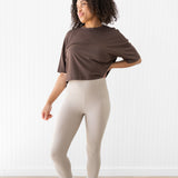 Model looking to the side while wearing the Flex Leggings in Bisque with hand on her hip
