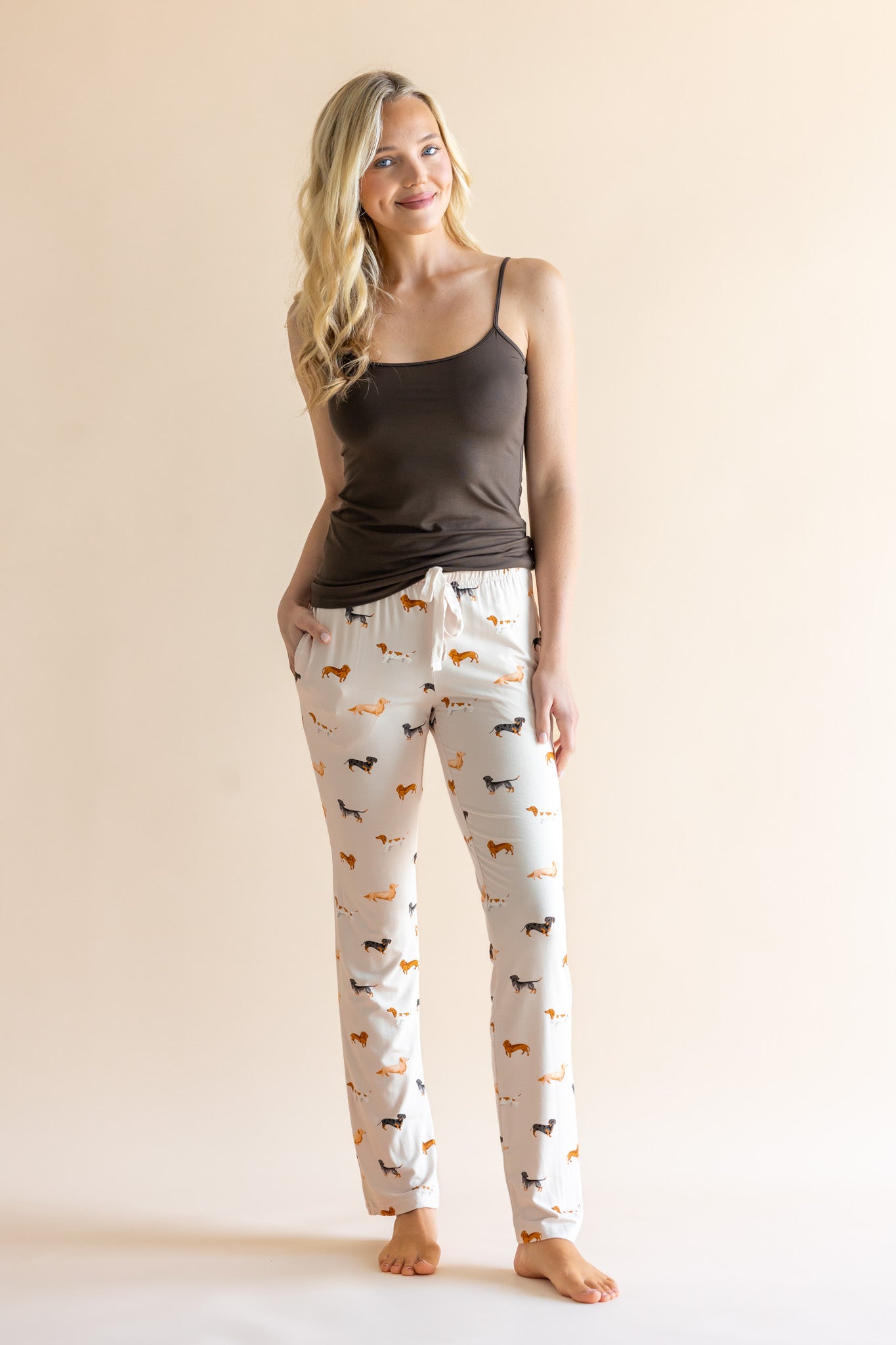 Model wearing Women's Lounge Pants in Dachshund paired with a camisole in espresso background 