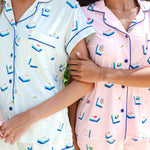 2 women wearing light green and pink short sleeve pajama set with mahjong tile print