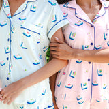 2 women wearing light green and pink short sleeve pajama set with mahjong tile print