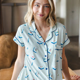 woman smiling light green short sleeve pajama set with mahjong tile print sitting in a living room ---PJ 2
