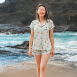 Woman modeling Women's Short Sleeve Pajama Set in Dew Surf with an ocean and cliff in the background