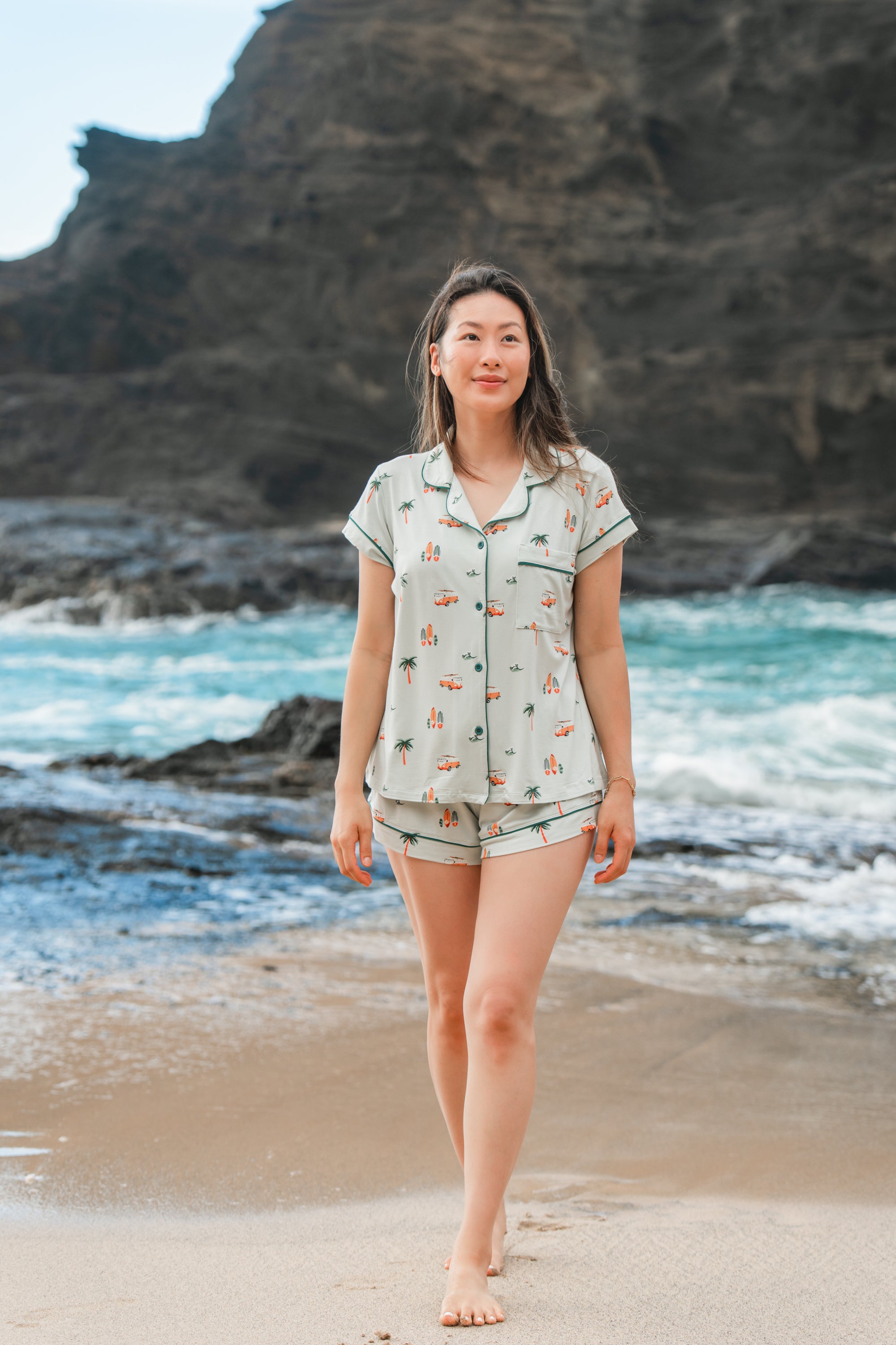 Woman modeling Women's Short Sleeve Pajama Set in Dew Surf with an ocean and cliff in the background