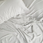 Close up of the Bamboo Sateen Sheet Set in Dove Gray shown on a bed