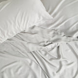 Close up of the Bamboo Sateen Sheet Set in Dove Gray shown on a bed