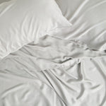 Bamboo Sateen Pillowcase Set in Dove Gray and matching bed sheets shown on a bed