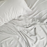 Bamboo Sateen Pillowcase Set in Dove Gray and matching bed sheets shown on a bed