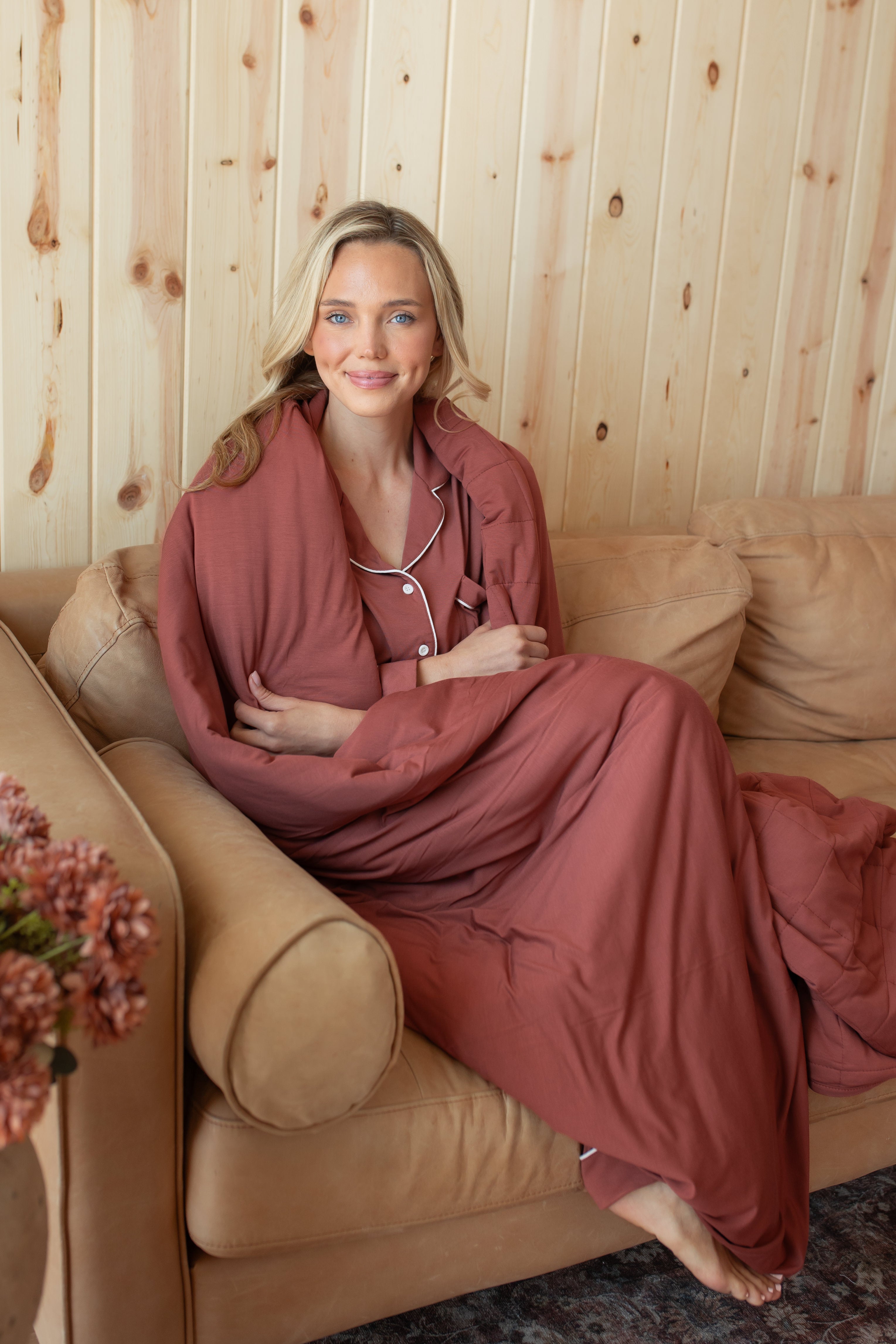 Model wrapped in Adult Quilted Blanket in Ember 2.5 sitting on the couch