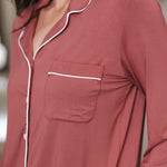 close up of Modal wearing Long-Sleeved Women's Pajama Set in Ember with pocket standing against a wall
