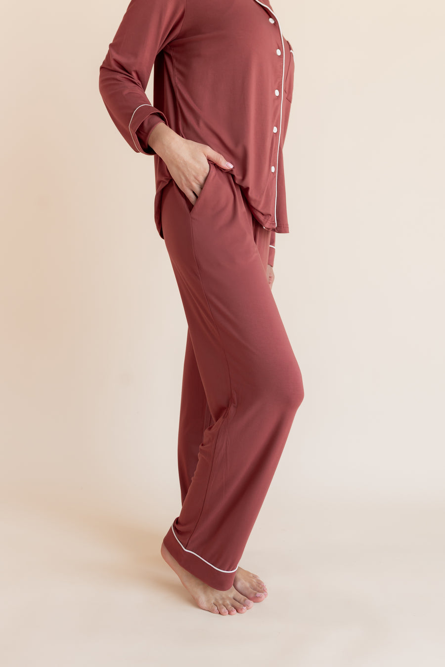 Model showcasing pockets on Long-Sleeved Women's Pajama Set in Ember on a beige background