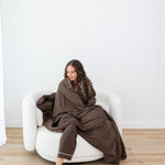Model wearing the Long Sleeve Pajama Set and  wrapped in Bamboo Quilt Blanket in Espresso 2.5