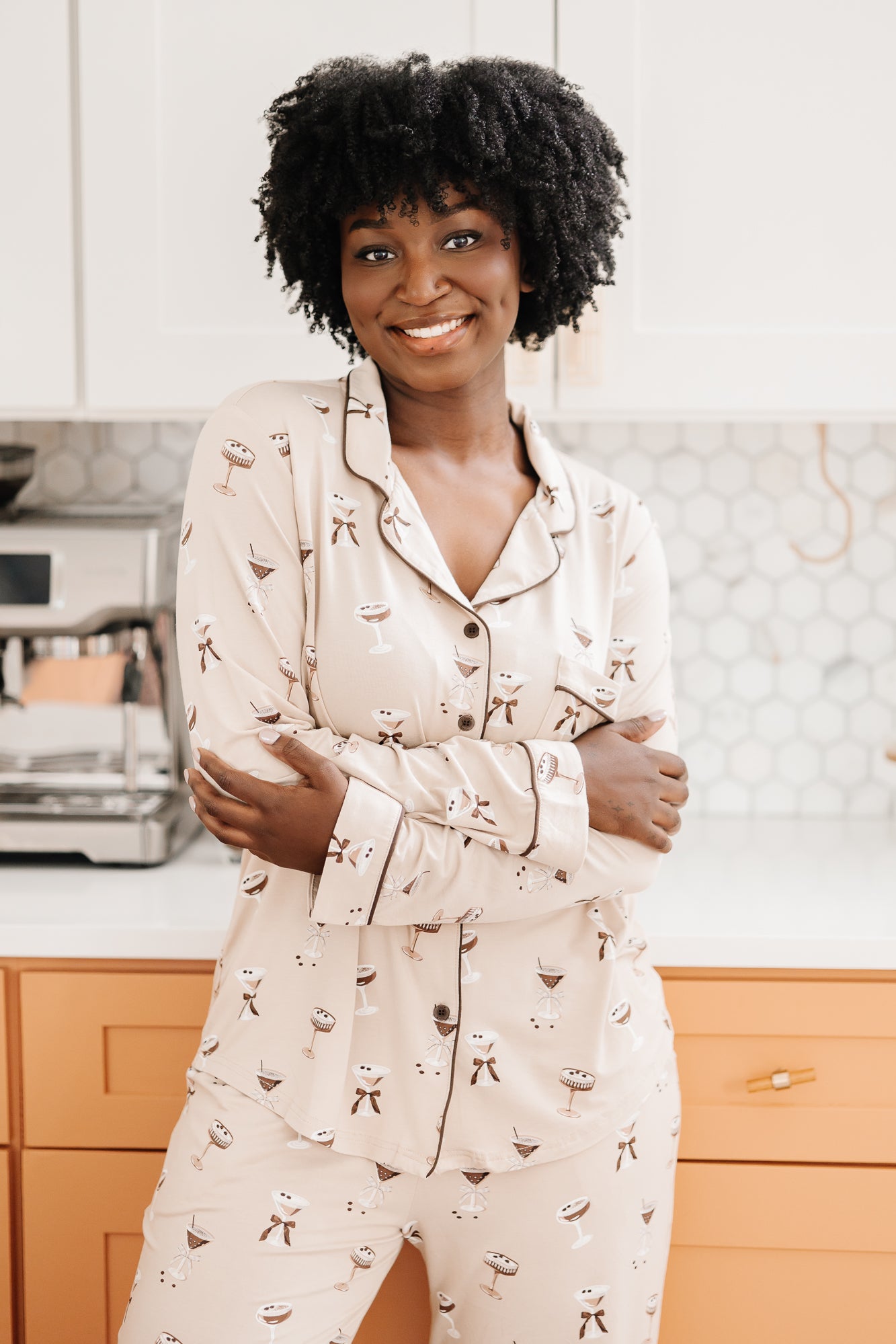 Woman with arms around her torso while modeling the Kyte Bamboo Long-Sleeved Women's Pajama Set in Espresso Martini