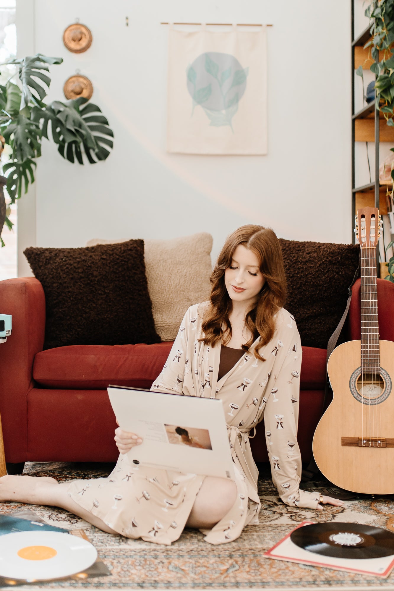 Woman sitting on the floor, next to a guitar while modeling the Women's Lounge Robe in Espresso Martini
