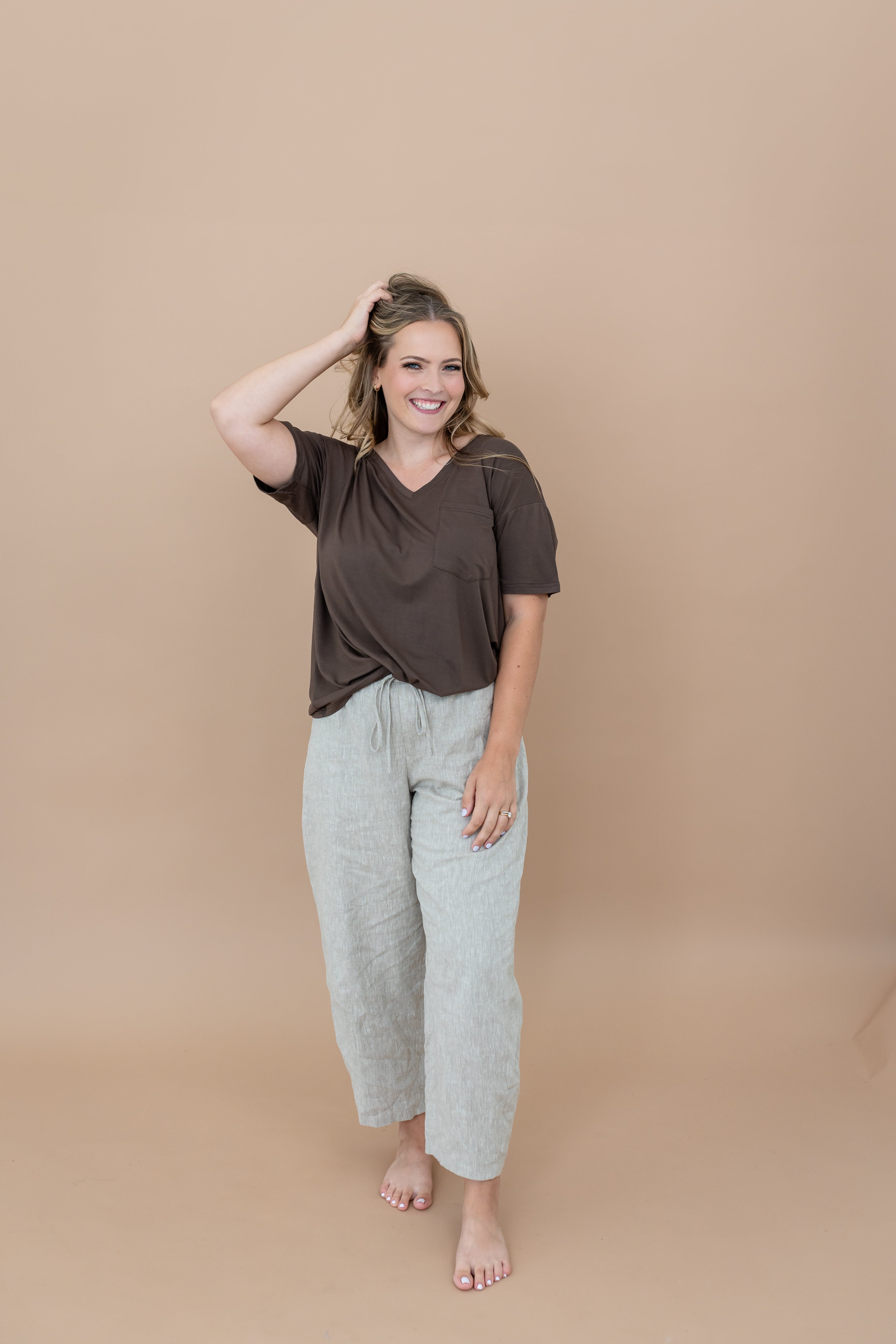 Smiling model with  her hand in her hair while modeling the Women's V Neck in Espresso 