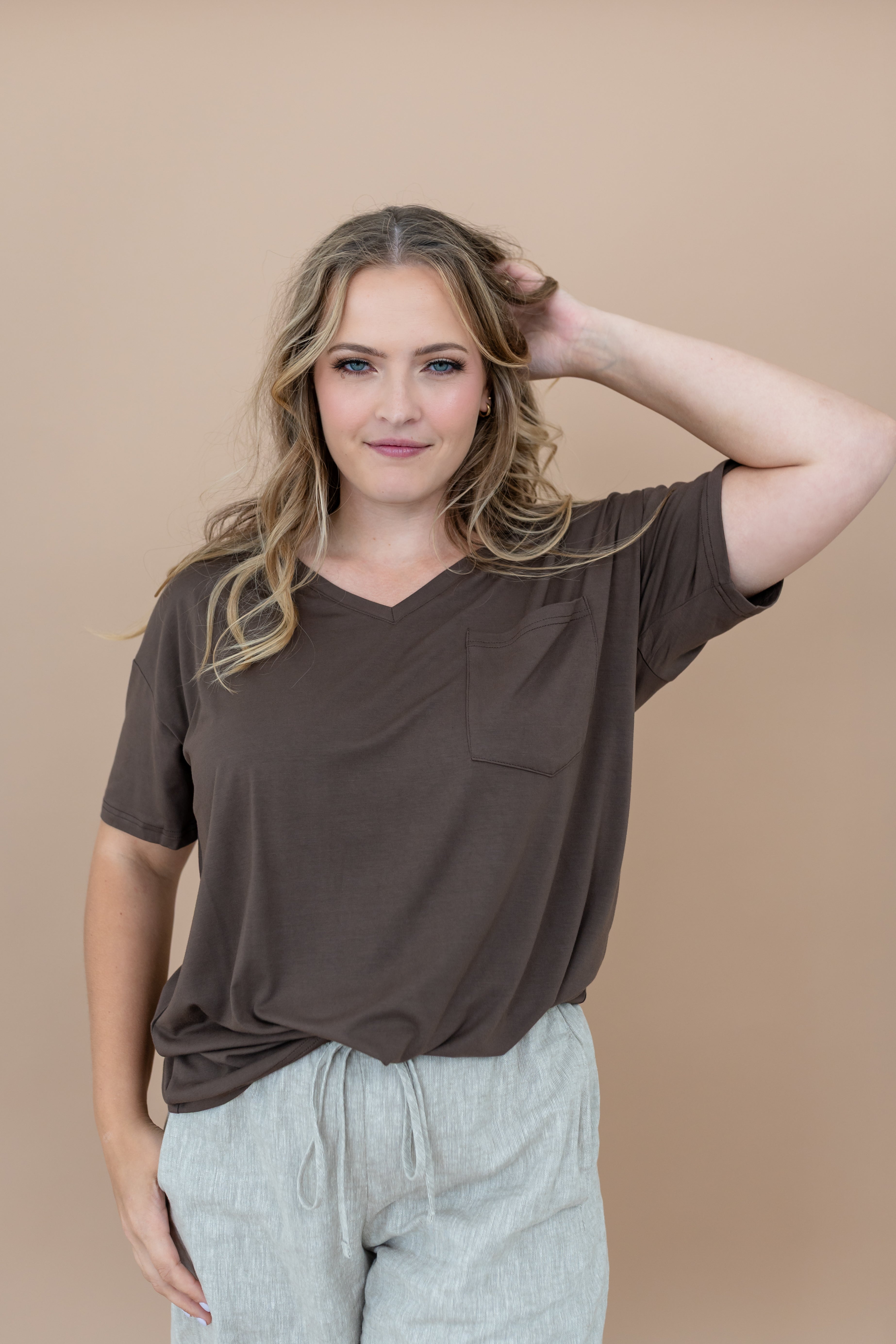 Women modeling the Kyte Women's V Neck in Espresso with one arm up 