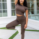 Female model posing wearing the Bamboo Flex Baby Tee in Espresso and matching leggings