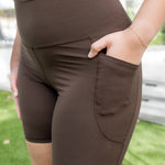 Female model wearing the Bamboo Flex High Rise Biker Short in Espresso with one hand in the side pocket

::: Model is 5'9" wearing size L ///