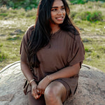 Model looking to the side wearing the Women's Biker Short Set in Espresso while sitting on a rock