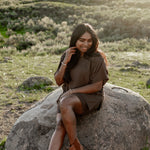 Model sitting on a rock while wearing the Women's Biker Short Set in Espresso 