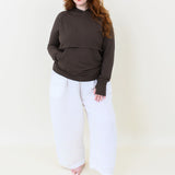 Female model wearing the Women's French Terry Nursing Hoodie in Espresso paired with white pants