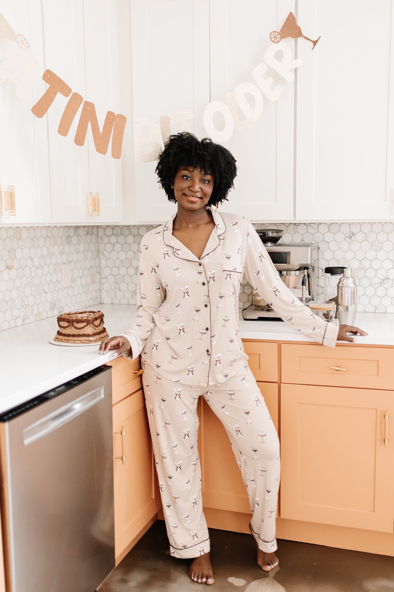 Model standing in front of a counter while modeling the Bamboo Long-Sleeved Women's Pajama Set in Espresso Martini
