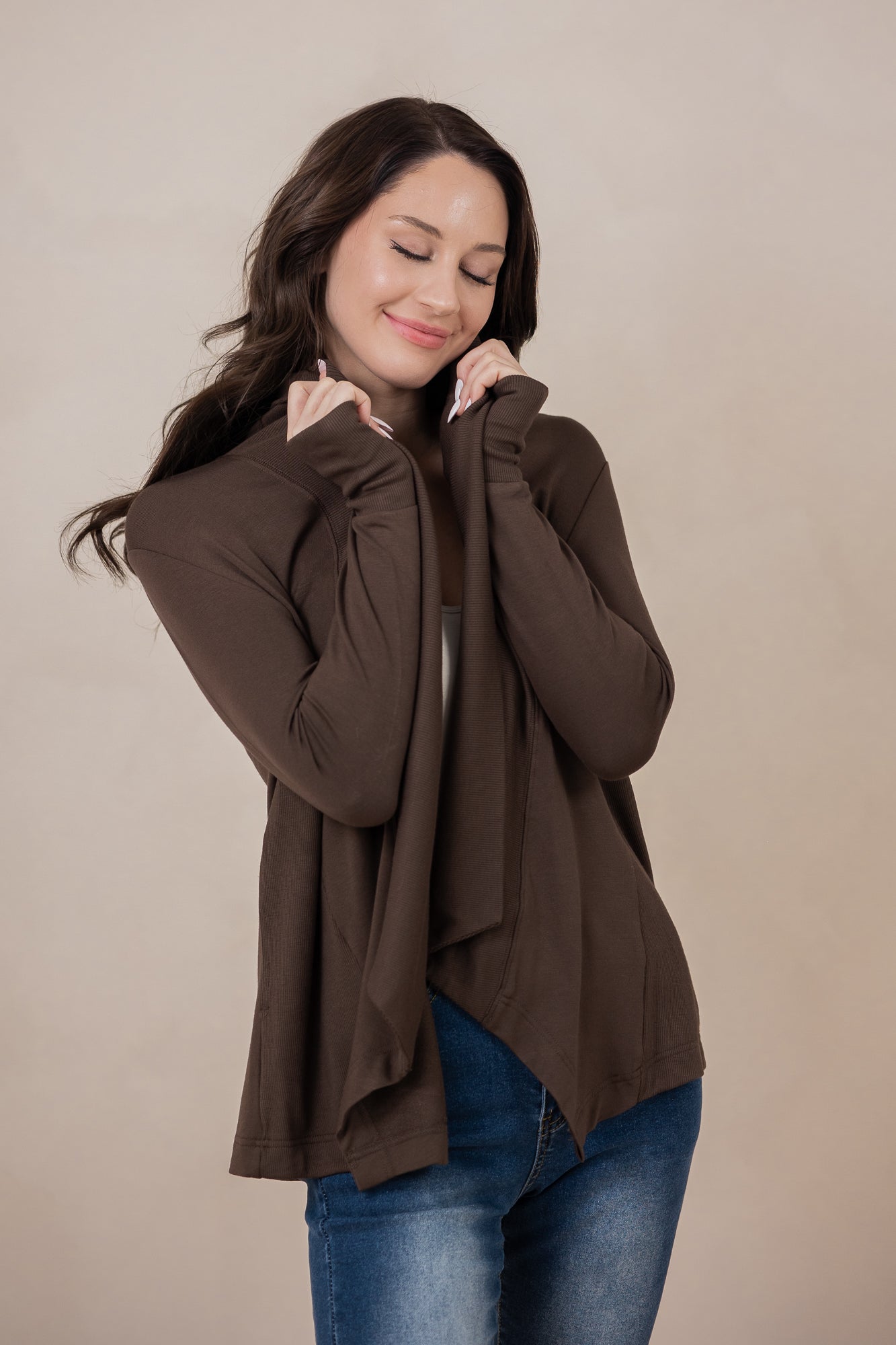 Woman holding the Women's French Terry Wrap Top in Espresso close towards her face with eyes closed