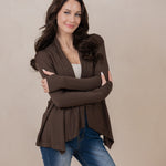 Model with arms around herself while wearing the Kyte Women's French Terry Wrap Top in Espresso paired with dark jeans