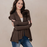 Model with arms around herself while wearing the Kyte Women's French Terry Wrap Top in Espresso paired with dark jeans