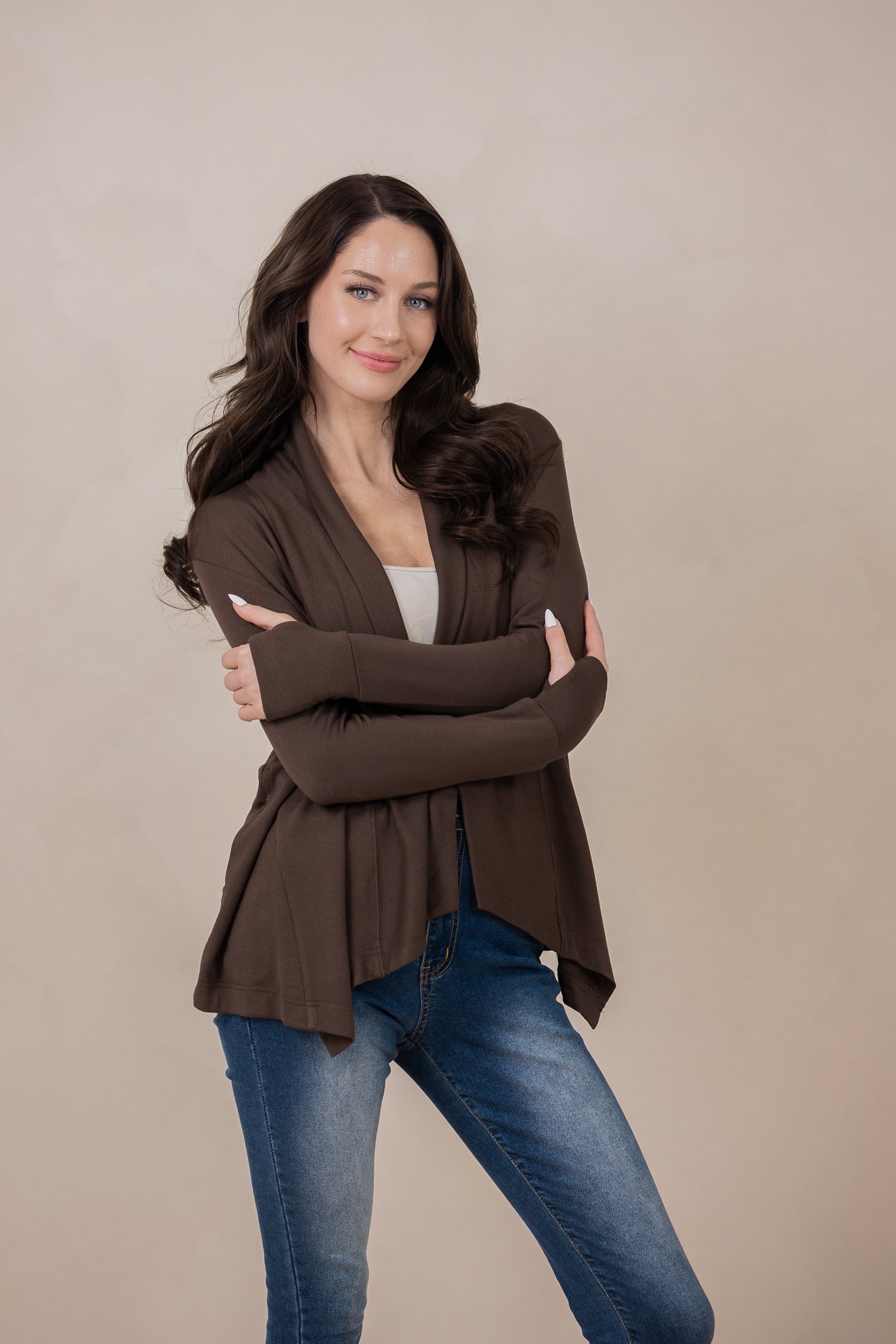 Model with arms around herself while wearing the Kyte Women's French Terry Wrap Top in Espresso paired with dark jeans
