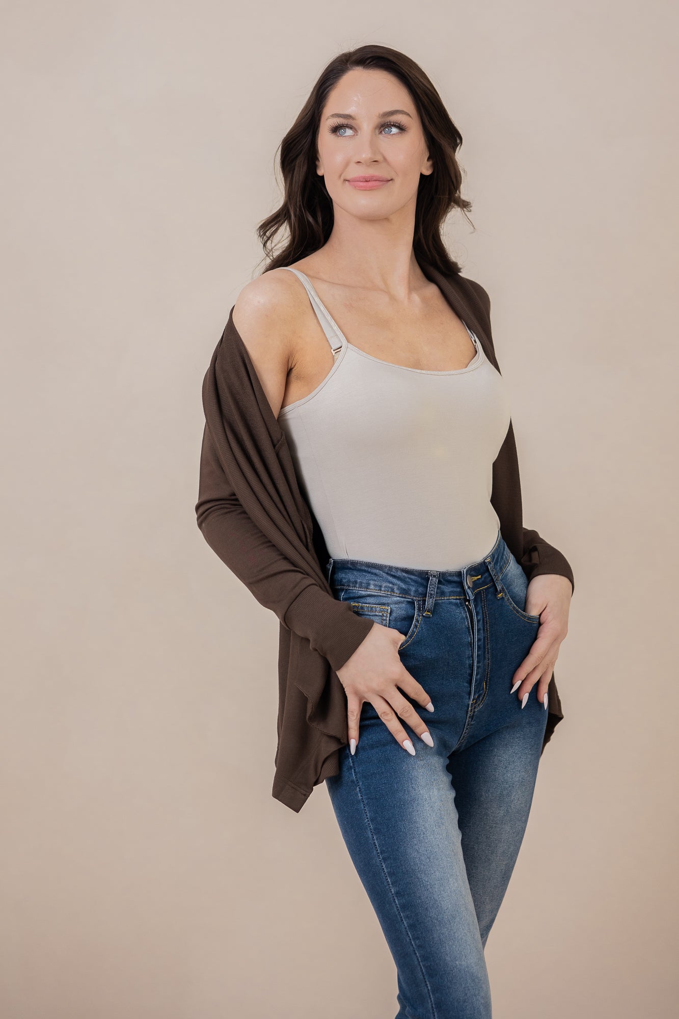 Model looking off to the side with the Women's French Terry Wrap Top in Espresso off one shoulder paired with a cami and jeans
