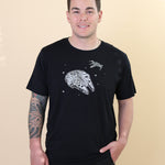 Male modeling the Men's Crew Neck Tee in Millennium Falcon™ with one hand in his jean pocket