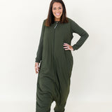 Smiling model wearing the Adult Sleep Bag Walker in Fir with hand on hip