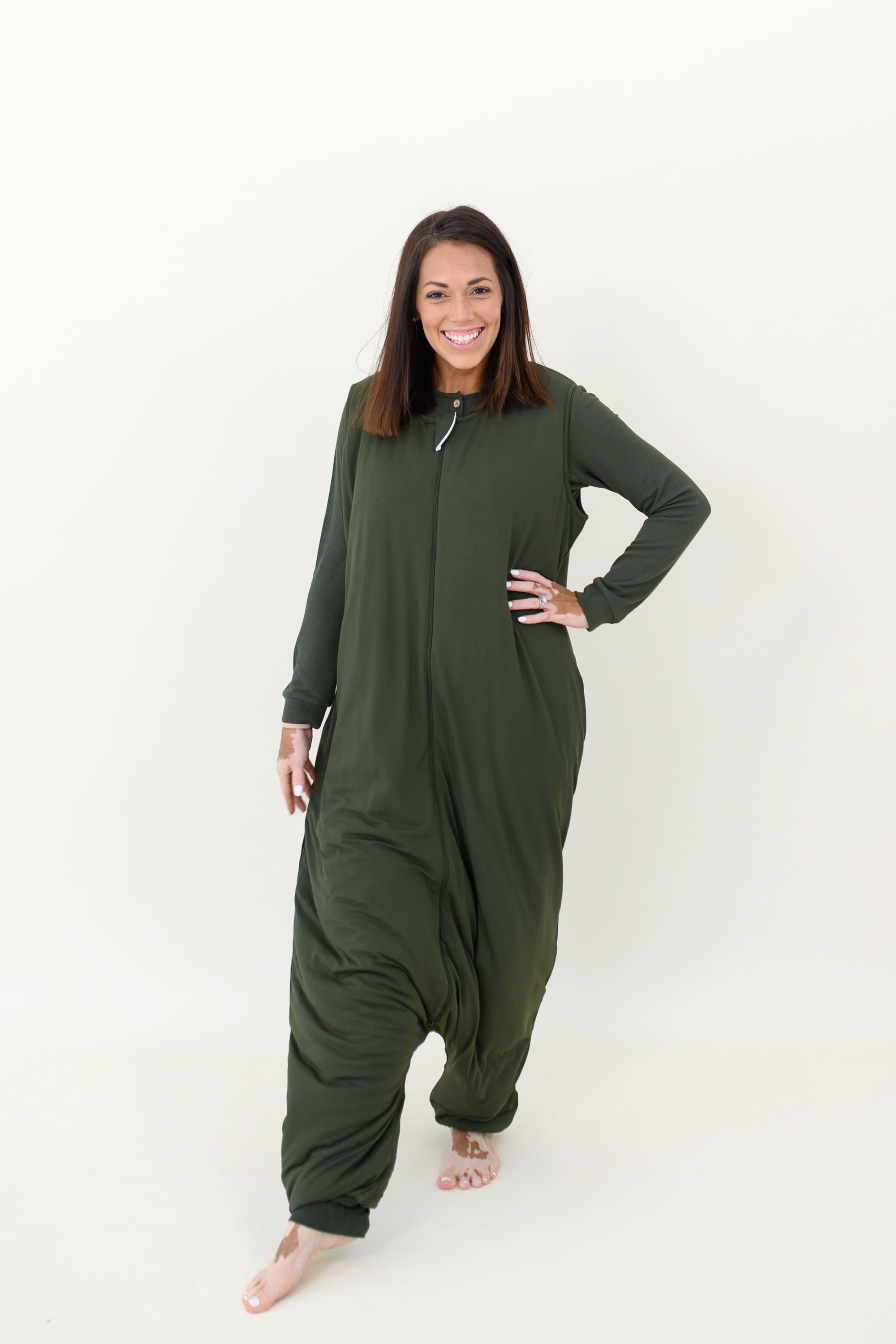 Smiling model wearing the Adult Sleep Bag Walker in Fir with hand on hip