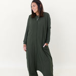 Model looking to the side while  wearing the Adult Sleep Bag Walker in Fir with a hand in the pocket