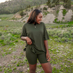 Model wearing Women’s Biker Short Set in Fir in an outdoor mountain landscape 