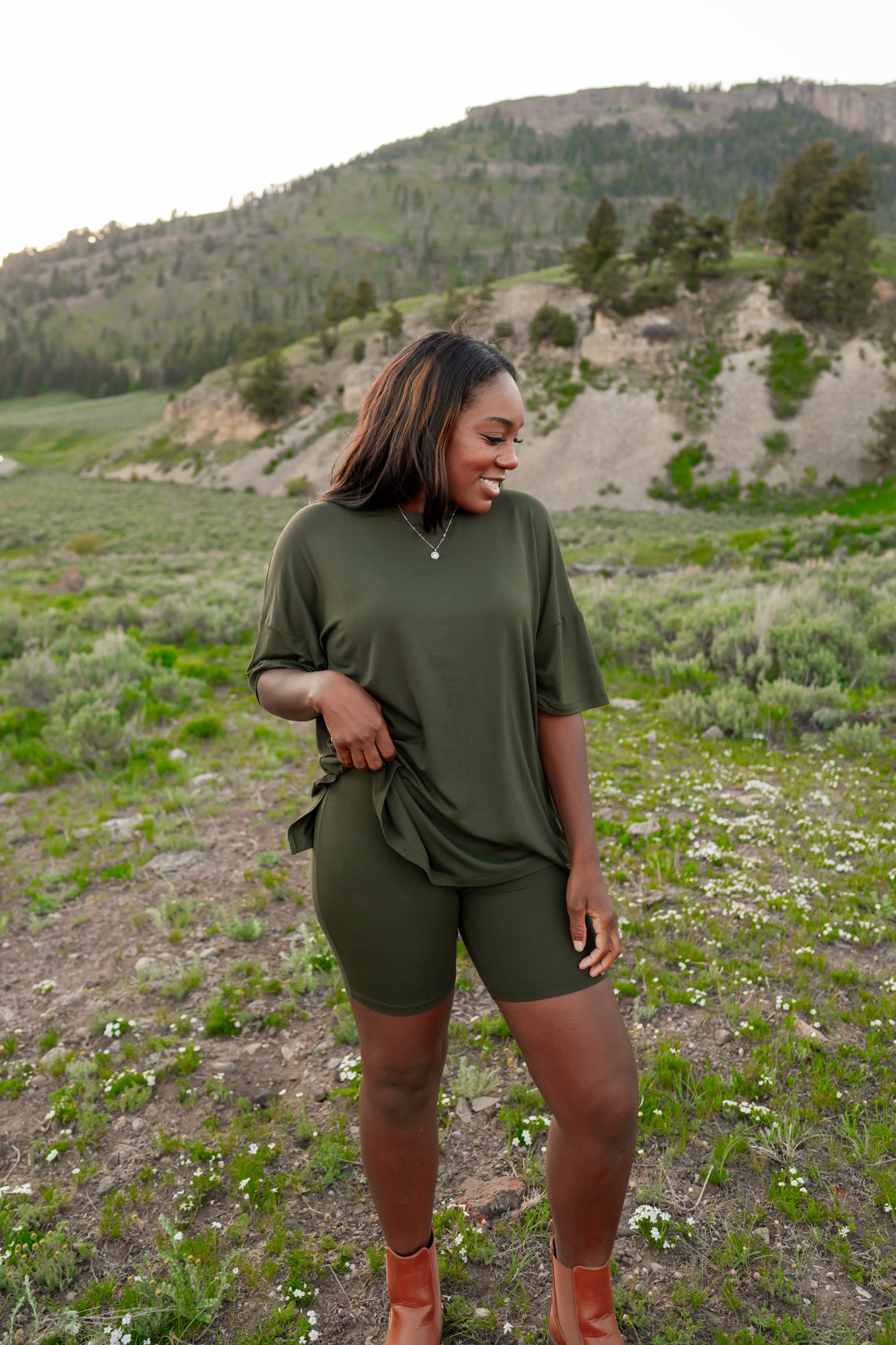 Model wearing Women’s Biker Short Set in Fir in an outdoor mountain landscape 