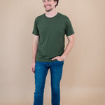 Male model stepping and looking to the side while wearing Kyte Men's Crew Neck Tee in Fir
