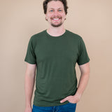 Smiling male model wearing the Kyte Men's Crew Neck Tee in Fir