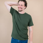 Man with one arm on head while modeling Kyte Men's Crew Neck Tee in Fir