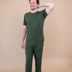 Male model wearing Men's Lounge Pants in Fir with one hand on head and matching crew neck tee
