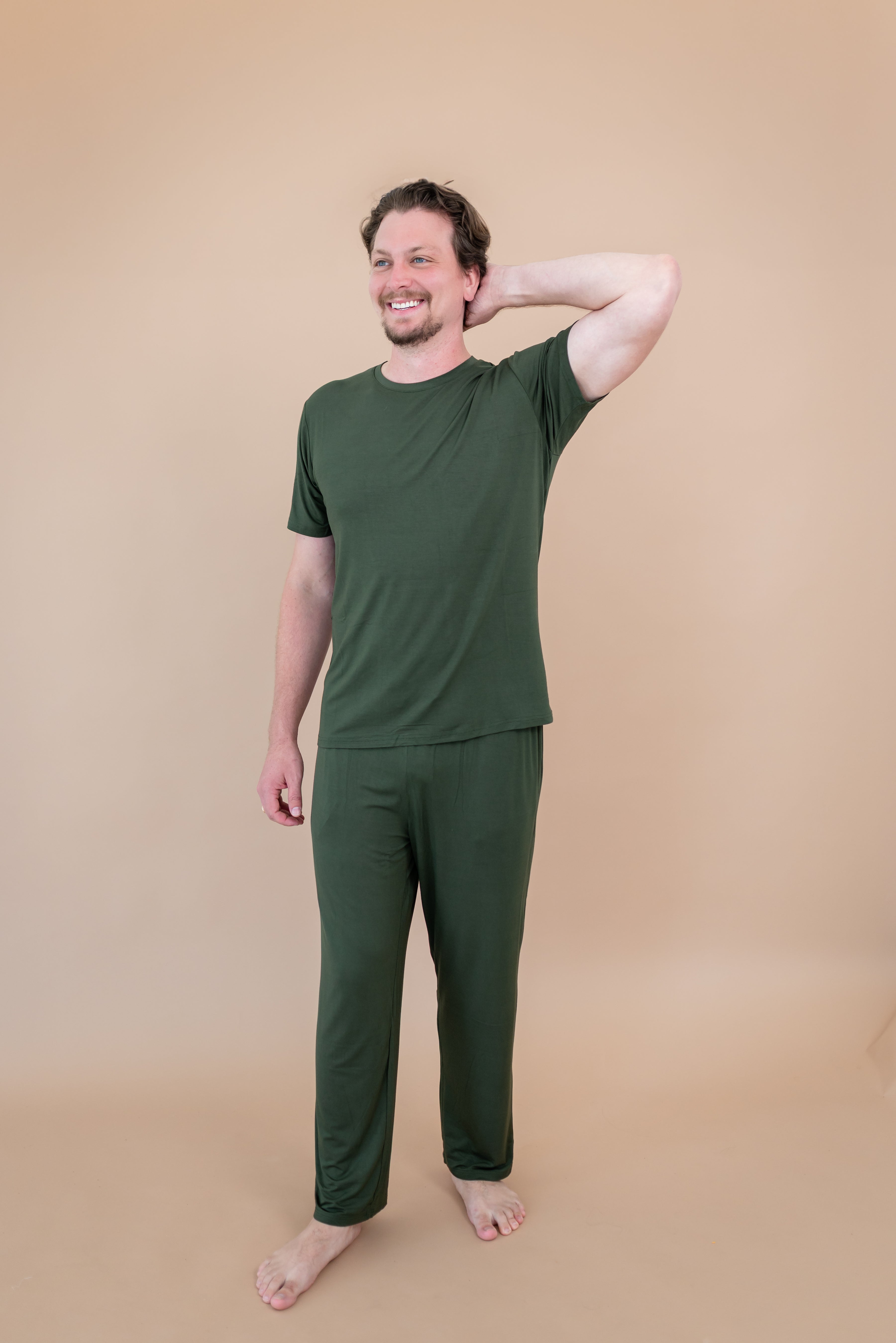 Male model wearing Men's Lounge Pants in Fir with one hand on head and matching crew neck tee