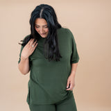 Model looking down while wearing the Kyte Women's Biker Short Set in Fir