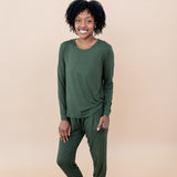 Model in a tan room wearing the Smiling model in grassy field wearing the Kyte Women's Jogger Set in Fir