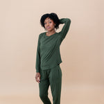 Women with hand in her hair while modeling the Women's Jogger Set in Fir