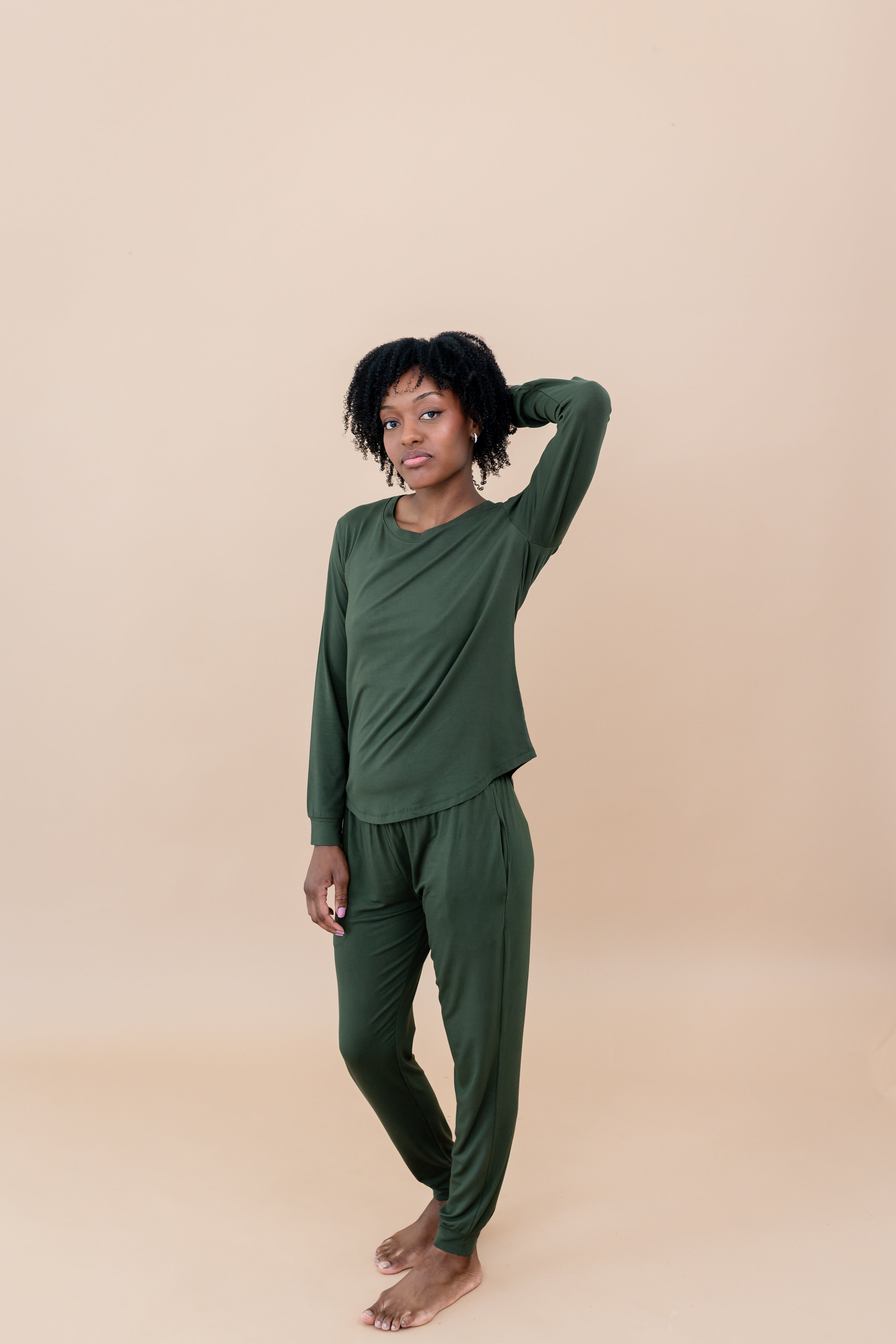 Women with hand in her hair while modeling the Women's Jogger Set in Fir
