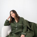 Model looking to the side while wrapped in the Quilt Blanket 2.5 and wearing Long Sleeve Pajama Set in Fir