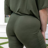 Person wearing an olive green outfit with shorts and a top.