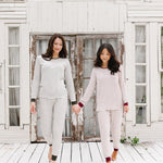 Models holding hands looking down while wearing the Women’s Ribbed Henley Set in Fir Stripe and Burgundy Stripe